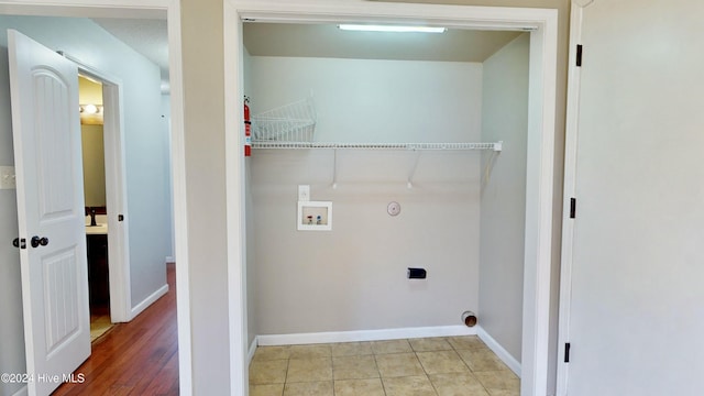 washroom with hookup for a washing machine, hookup for a gas dryer, light hardwood / wood-style flooring, and hookup for an electric dryer