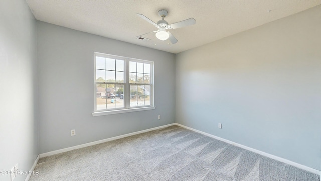 carpeted empty room featuring ceiling fan and a textured ceiling