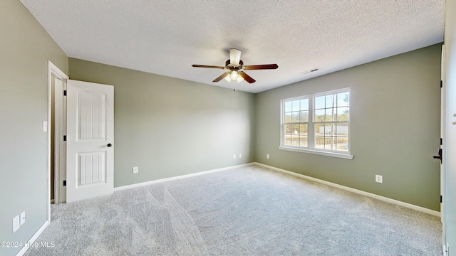 empty room with ceiling fan, a textured ceiling, and light carpet