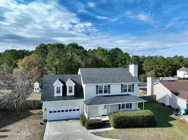 view of front of house with a front lawn, a porch, and a garage