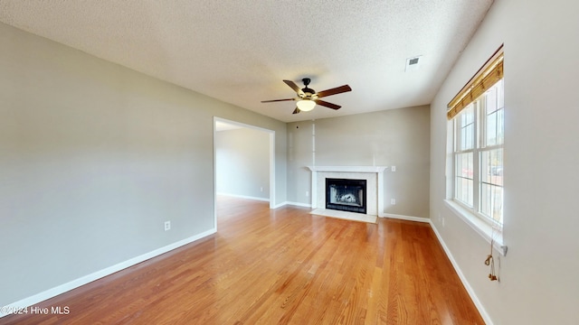 unfurnished living room featuring a textured ceiling, light hardwood / wood-style floors, and ceiling fan