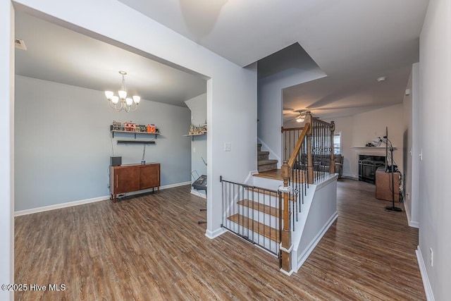 stairs with ceiling fan with notable chandelier and hardwood / wood-style flooring