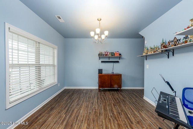 unfurnished office featuring dark hardwood / wood-style floors and a chandelier