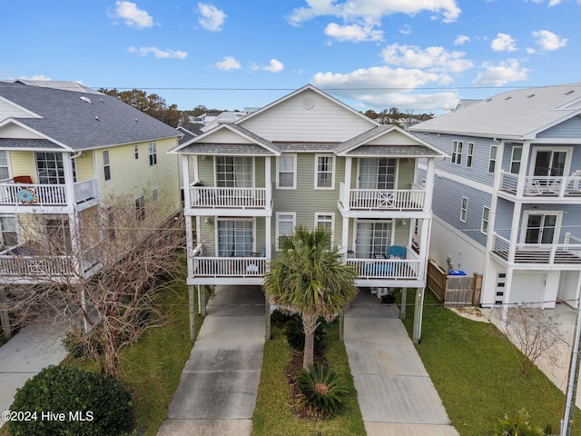 view of front of house with a balcony, a front yard, and a carport