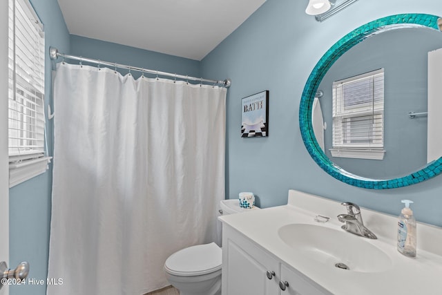 bathroom featuring vanity, toilet, and plenty of natural light