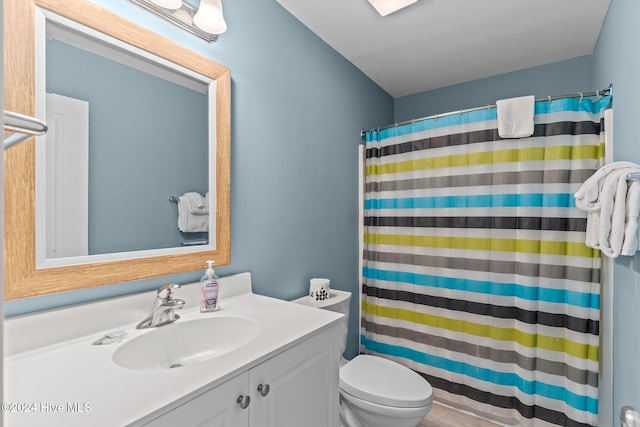 bathroom with a shower with shower curtain, vanity, and toilet