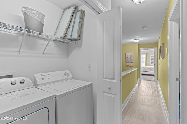 laundry area featuring separate washer and dryer and light hardwood / wood-style flooring