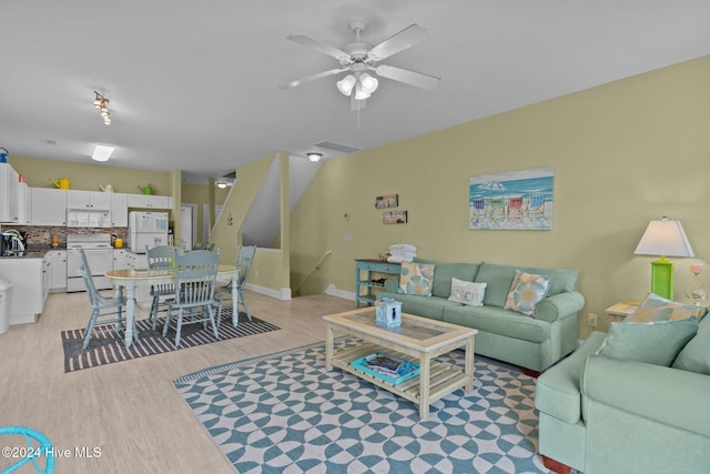 living room featuring light hardwood / wood-style floors and ceiling fan