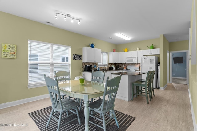 dining space with sink and light hardwood / wood-style floors