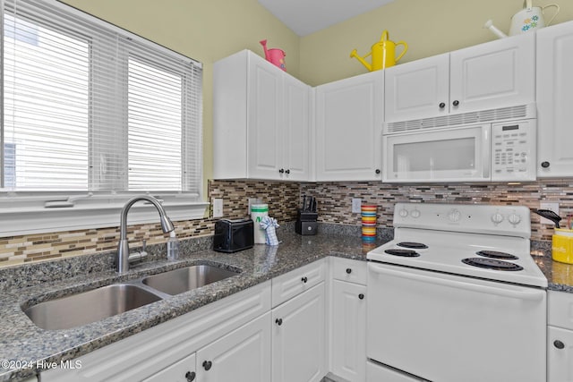 kitchen featuring dark stone countertops, white cabinetry, sink, and white appliances