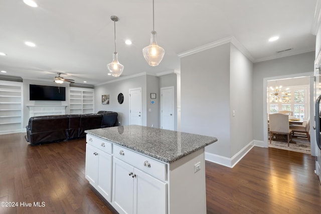 kitchen with white cabinets, ceiling fan with notable chandelier, light stone countertops, built in features, and decorative light fixtures