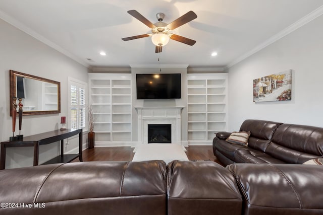 living room with a high end fireplace, dark hardwood / wood-style flooring, ceiling fan, crown molding, and built in features