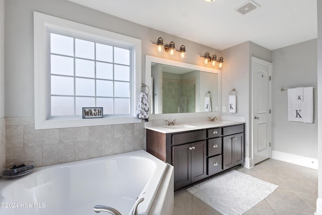 bathroom with tile patterned floors, a bathing tub, and vanity