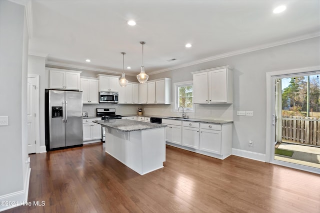 kitchen featuring a center island, hanging light fixtures, backsplash, stone countertops, and appliances with stainless steel finishes