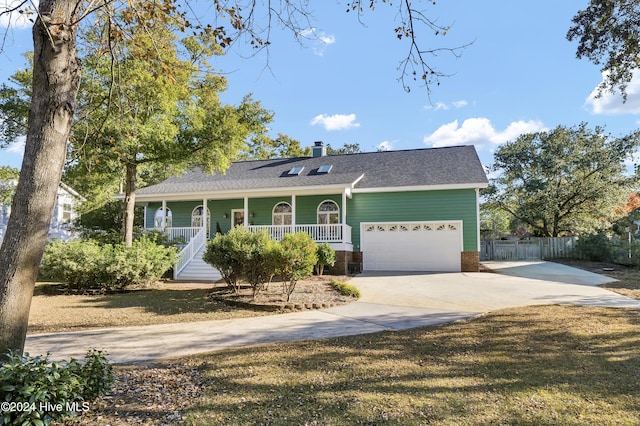 view of front of property featuring covered porch, a garage, and a front lawn