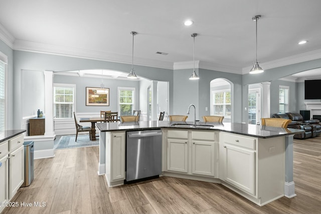 kitchen featuring stainless steel dishwasher, a center island with sink, sink, and pendant lighting