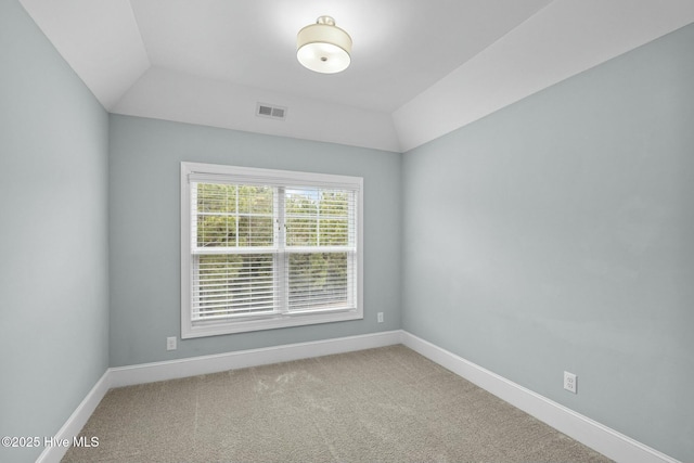 carpeted spare room featuring lofted ceiling