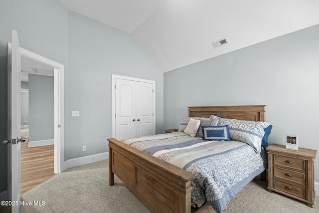 carpeted bedroom with a closet and vaulted ceiling