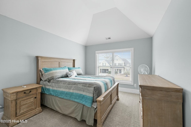 bedroom with light carpet and lofted ceiling