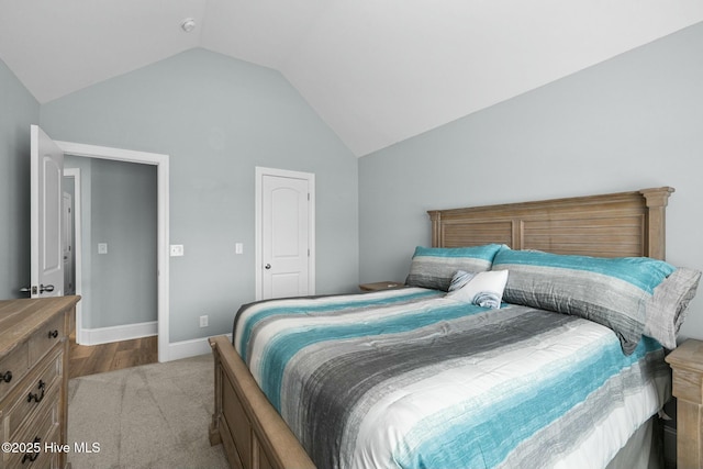 carpeted bedroom featuring lofted ceiling