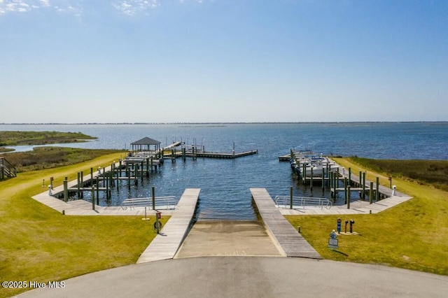 view of dock featuring a lawn and a water view