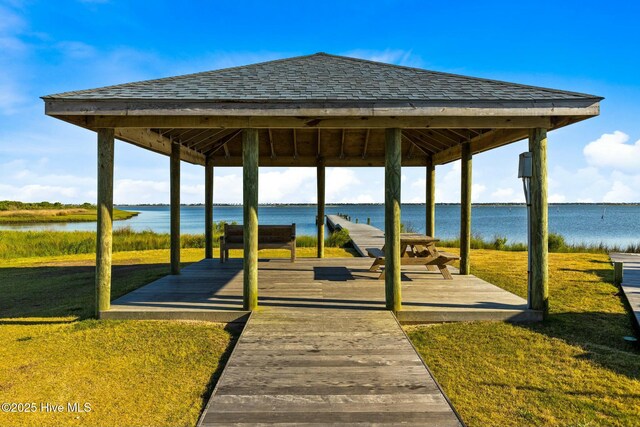 view of property's community with a lawn, a water view, and a gazebo