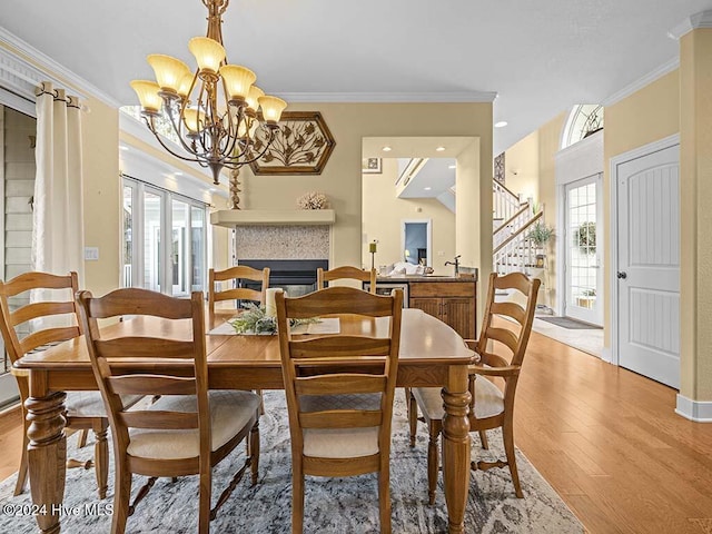 dining space with light wood-type flooring, a wealth of natural light, and crown molding