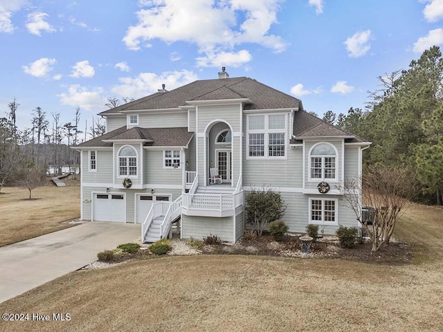 view of front of home featuring cooling unit, a front lawn, covered porch, and a garage