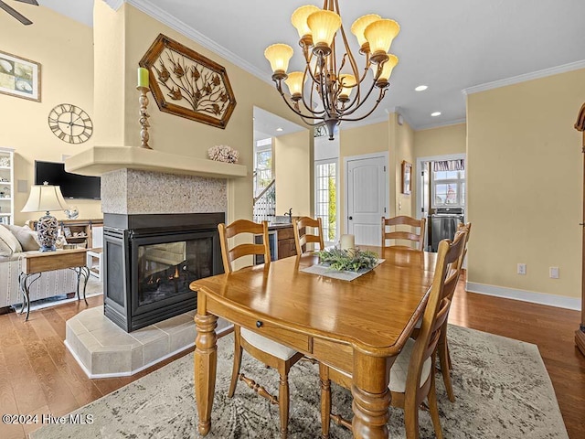 dining space featuring a tile fireplace, hardwood / wood-style flooring, and ornamental molding