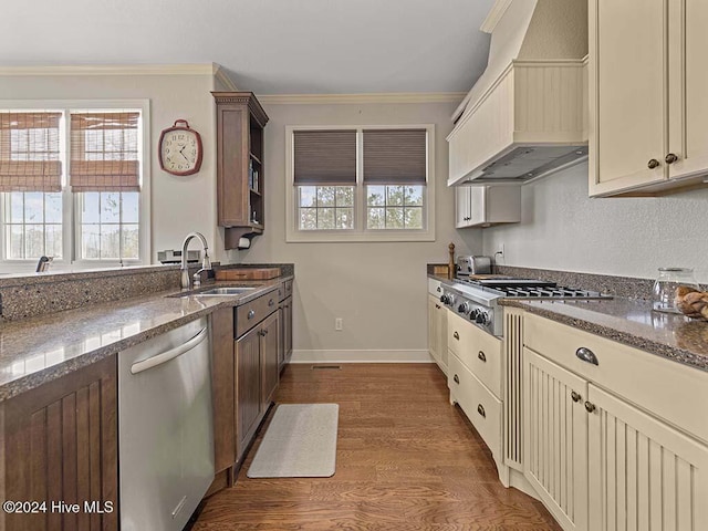 kitchen with appliances with stainless steel finishes, custom exhaust hood, and cream cabinetry