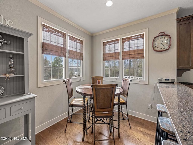 dining space with hardwood / wood-style flooring and ornamental molding