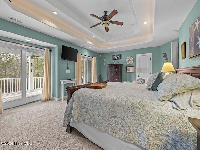 bedroom featuring a raised ceiling, ceiling fan, access to exterior, and carpet floors