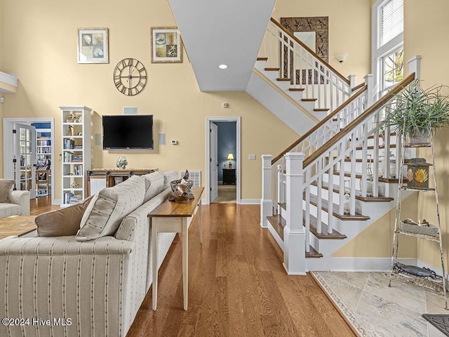 living room featuring wood-type flooring and a high ceiling