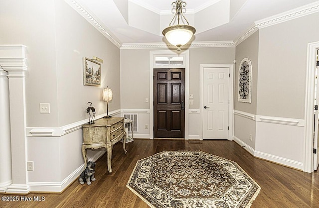 entrance foyer with a raised ceiling, dark hardwood / wood-style floors, and ornamental molding