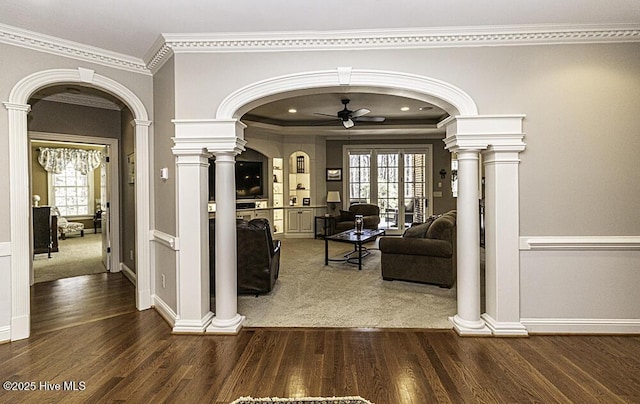 hallway featuring dark hardwood / wood-style flooring, ornamental molding, and ornate columns