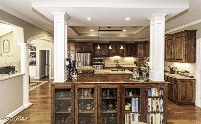 kitchen with stainless steel appliances, a raised ceiling, dark hardwood / wood-style flooring, pendant lighting, and dark brown cabinetry