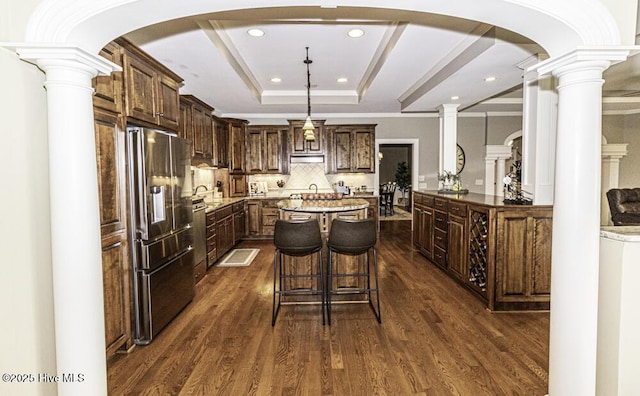 kitchen featuring decorative backsplash, dark wood-type flooring, a center island, and high end fridge