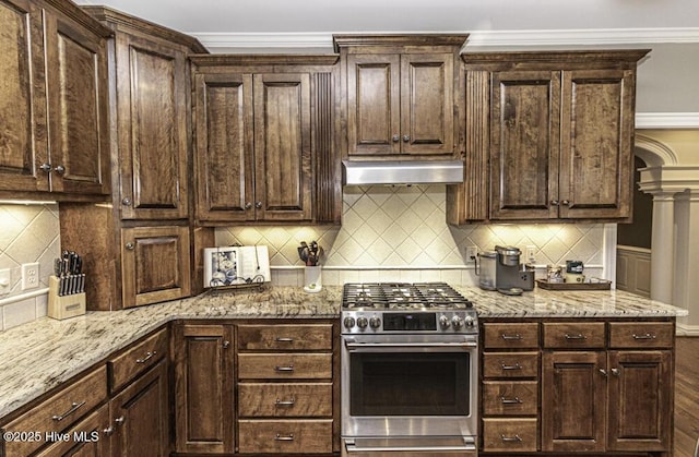 kitchen with dark brown cabinetry, ornate columns, and stainless steel range with gas stovetop