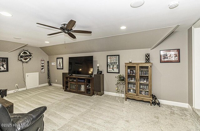 living room with ceiling fan, vaulted ceiling, and carpet