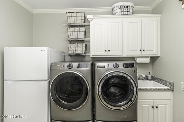 washroom with washing machine and dryer, cabinets, crown molding, and sink