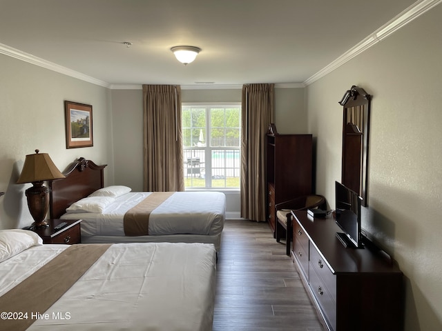 bedroom with crown molding and dark hardwood / wood-style floors