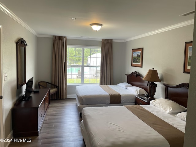 bedroom with dark hardwood / wood-style flooring and crown molding