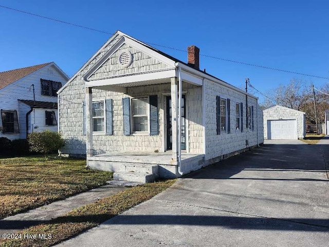 view of front of house featuring an outbuilding, a porch, and a garage