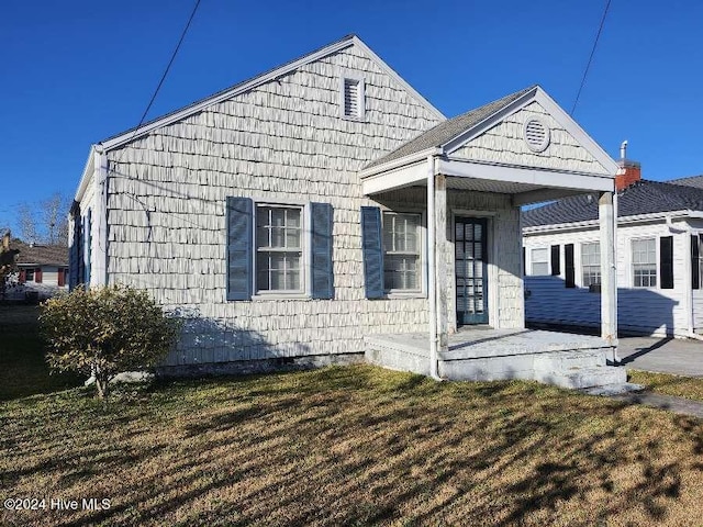 view of side of property with covered porch and a yard