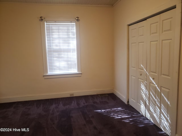 carpeted spare room featuring crown molding