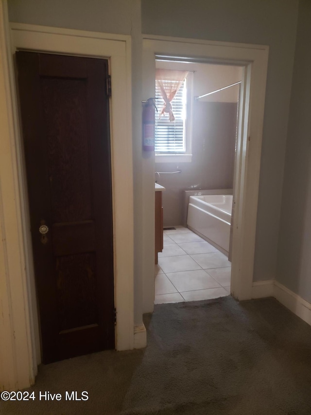 bathroom featuring a washtub and tile patterned flooring