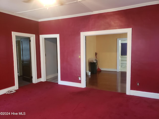 spare room featuring crown molding and carpet