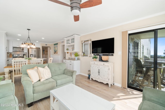 living room with ceiling fan with notable chandelier, light hardwood / wood-style flooring, and crown molding