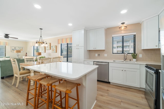 kitchen with appliances with stainless steel finishes, white cabinetry, and sink