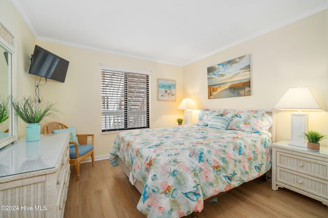 bedroom with light hardwood / wood-style flooring and crown molding